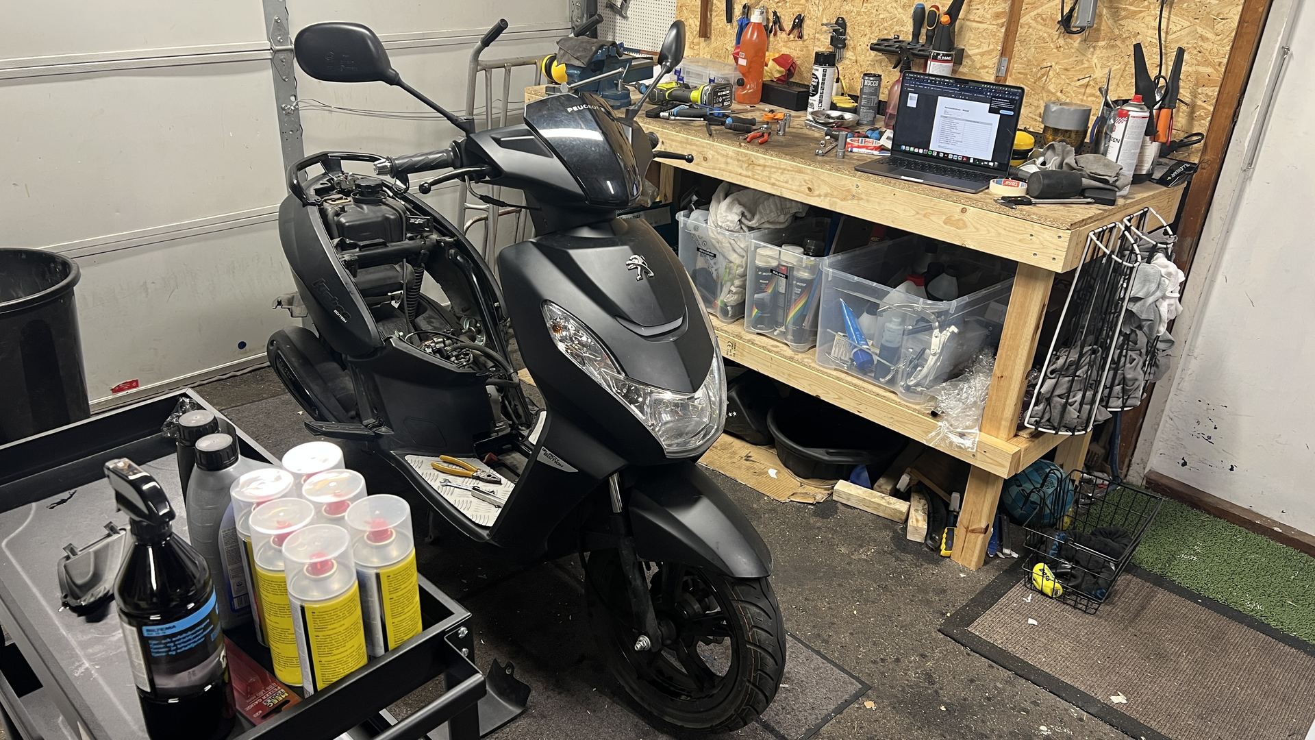 Svart scooter framför arbetsbänken i verkstaden