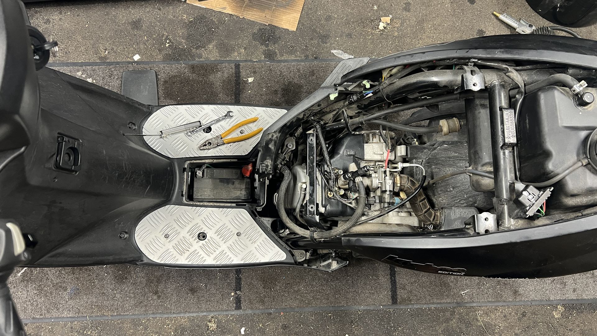 Scooter med kåporna av och motorn frilagd
